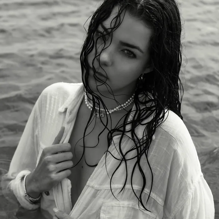 Black and white portrait with wet hair and an open white shirt
