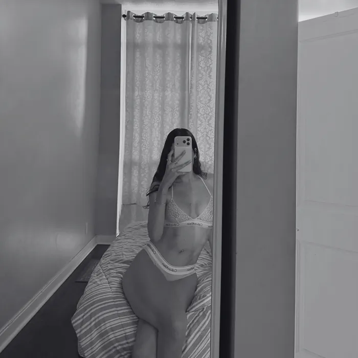 Black and white mirror selfie in a narrow bathroom