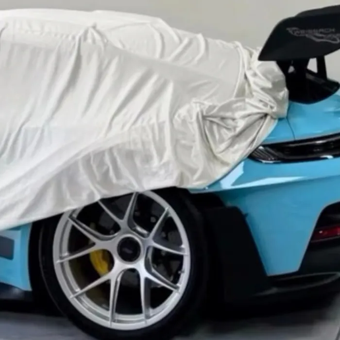 Covered car with one pale blue wheel arch showing